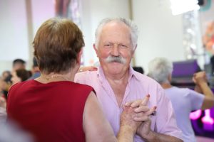 Homem idoso dançando com uma mulher idosa.