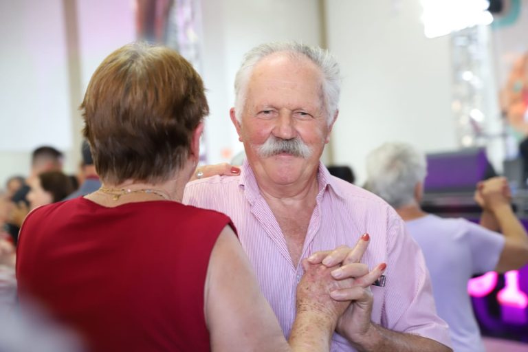 Homem idoso dançando com uma mulher idosa.
